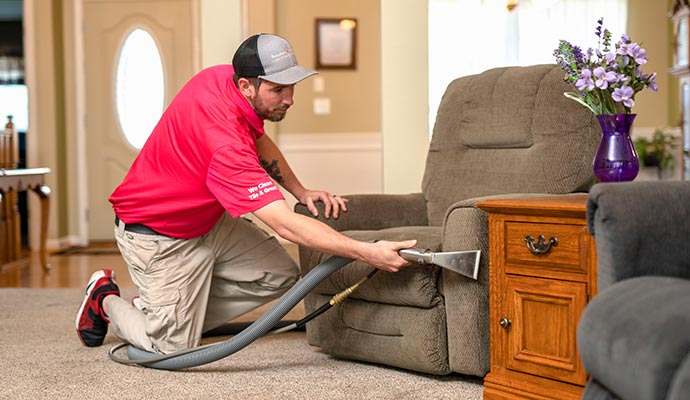 A Work-man cleaning upholstery and furniture.