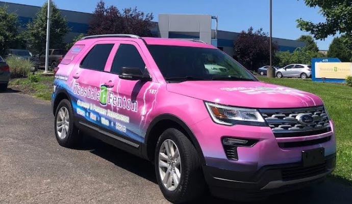 Teasdale Fenton property restoration vehicle A bright pink Teasdale Fenton service vehicle.