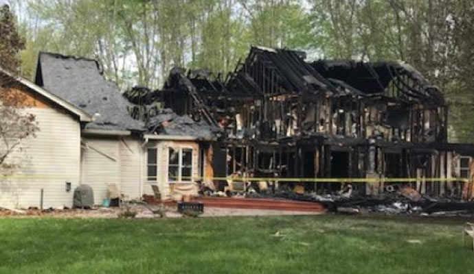 A house severely burned with visible fire damage