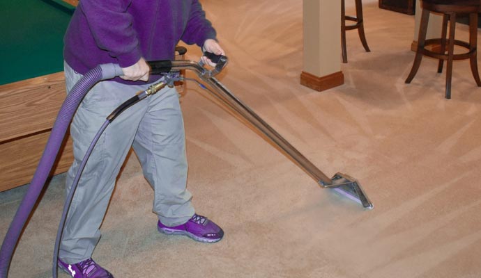 a person cleaning carpet with vaccume cleaner