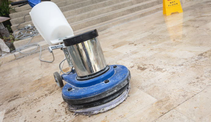 Expert worker cleaning floor with professional tools