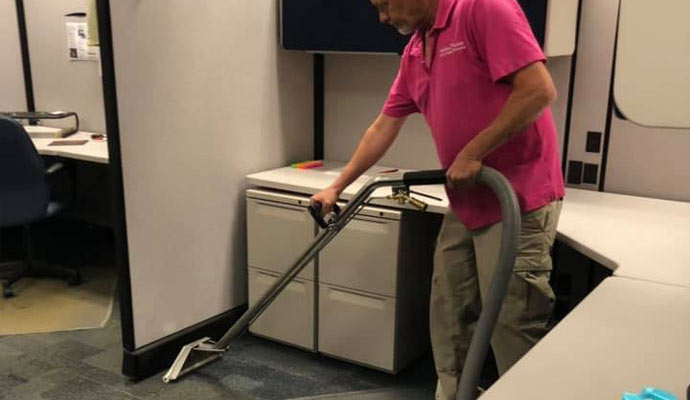 professional worker cleaning carpet in a office with carpet cleaning machine