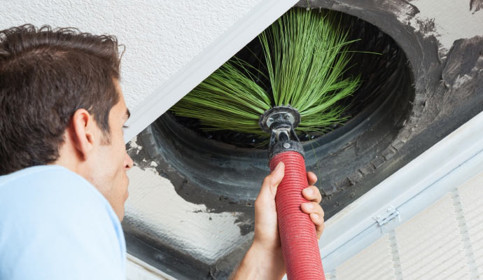 A person cleaning an air duct with equipment