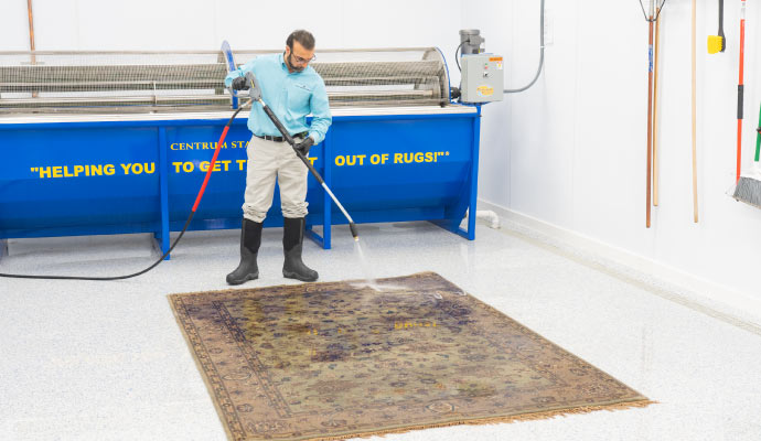 A person cleaning rug with equipment