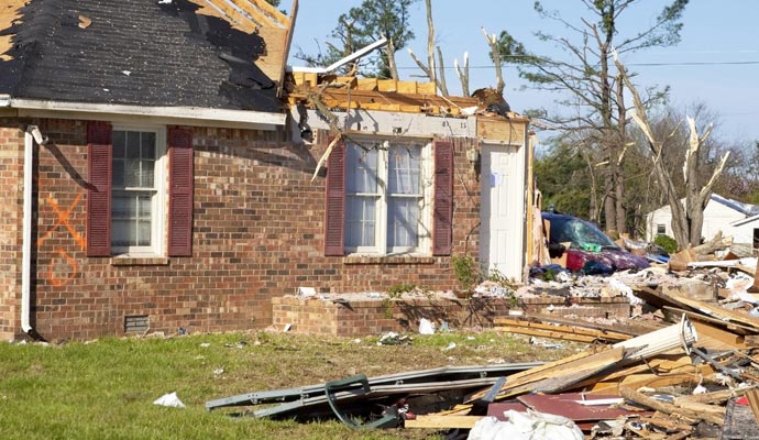 storm damaged property with clutter in the front-yard