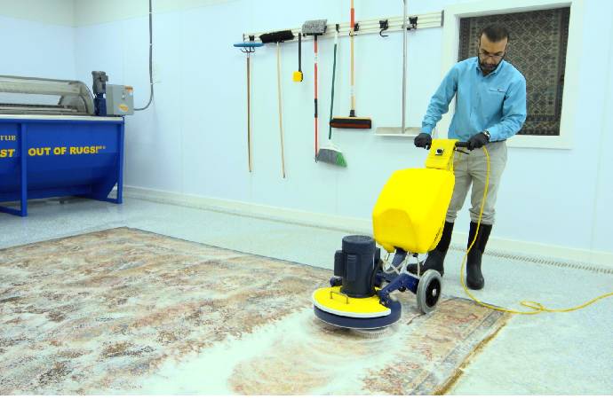 An employee cleaning rug with industrial rug cleaner