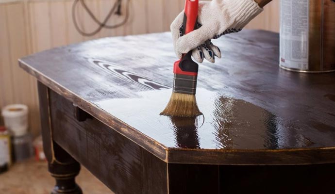 Applying stain on a restored furniture