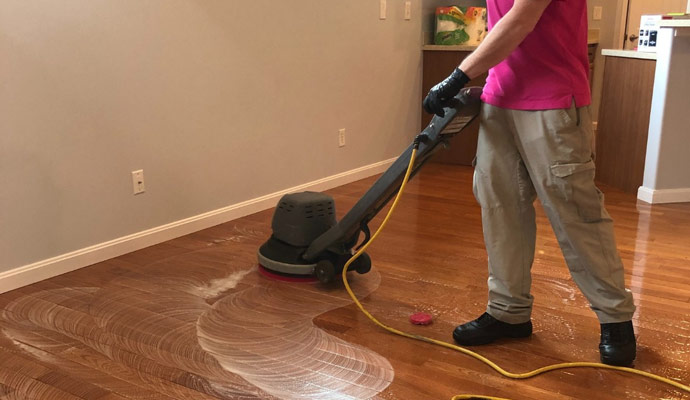 Person cleaning wood floor with industrial cleaner